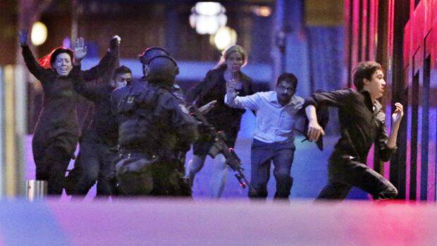 Hostages flee the siege in the early hours of the morning.  Photo: Andrew Meares
