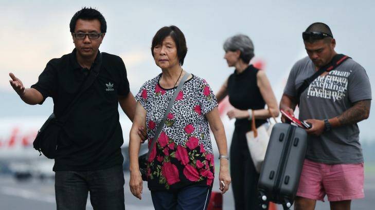 Australian Consulate staff assist Helen Chan, the mother of Bali Nine member Andrew Chan, followed by his brother Michael Chan as they arrive at Yogyarkarta airport. Photo: Kate Geraghty