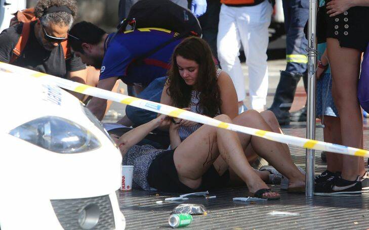 Injured people are treated in Barcelona, Spain, Thursday, Aug. 17, 2017 after a white van jumped the sidewalk in the historic Las Ramblas district, crashing into a summer crowd of residents and tourists and injuring several people, police said. (AP Photo/Oriol Duran)
