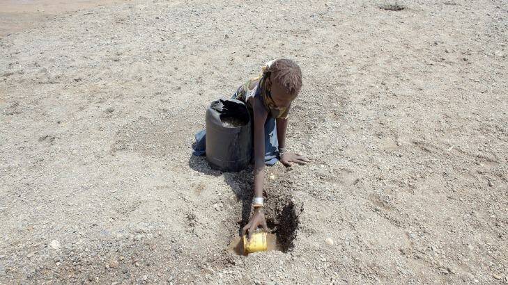 A young girl from the remote Turkana tribe in Northern Kenya digs a hole in a river bed to retrieve water. Over 23 million people across East Africa are facing a critical shortage of water and food, a situation made worse by climate change. Photo: Christopher Furlong/Getty Images