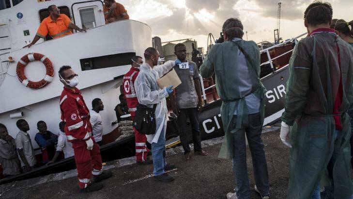 Processing: Refugees from Gambia, Nigeria, Ghana, Bangladesh, Afghanistan and other countries disembark an Italian commercial ship after being rescued at sea. Photo: New York Times
