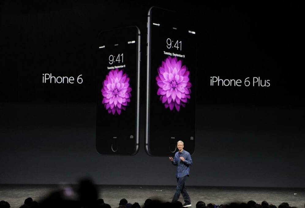Apple chief executive Tim Cook showcasing the iPhone 6 and iPhone 6 Plus.