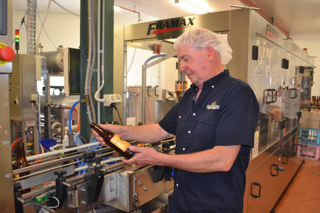 Belting along: Bernard Ryan inspects the first bottles of ginger beer made on the factory s new equipment.