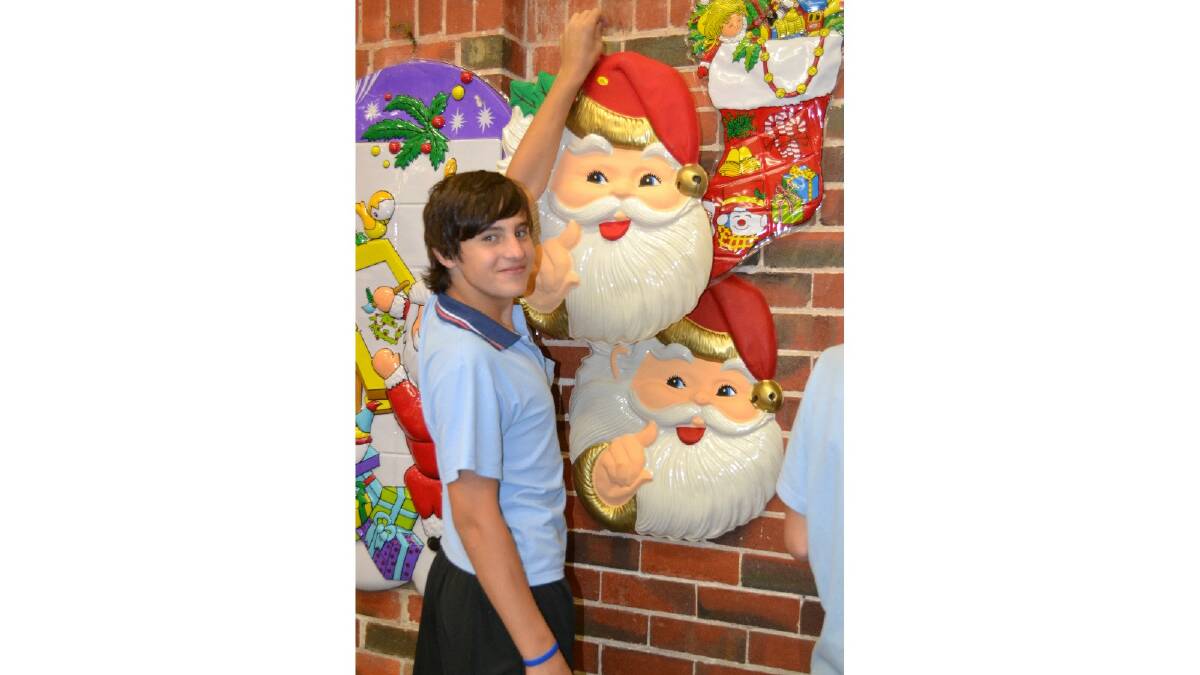 Deck the halls: Harley Underdown hanging his Santa in preparation of the Cheerio Christmas lunch. Photo: Collie Mail.