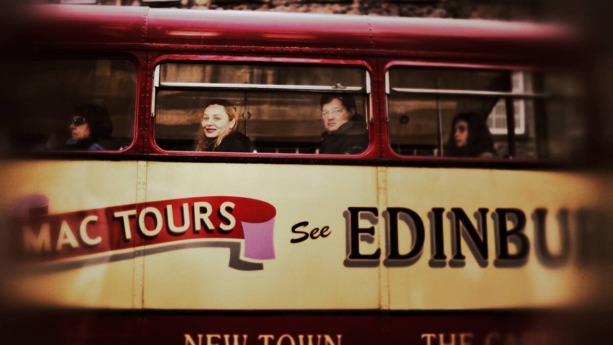 A woman smiles as she looks from a tourist bus on the Royal Mile on April 23, 2014 in Edinburgh, Scotland. pic: Jeff J Mitchell/Getty Image