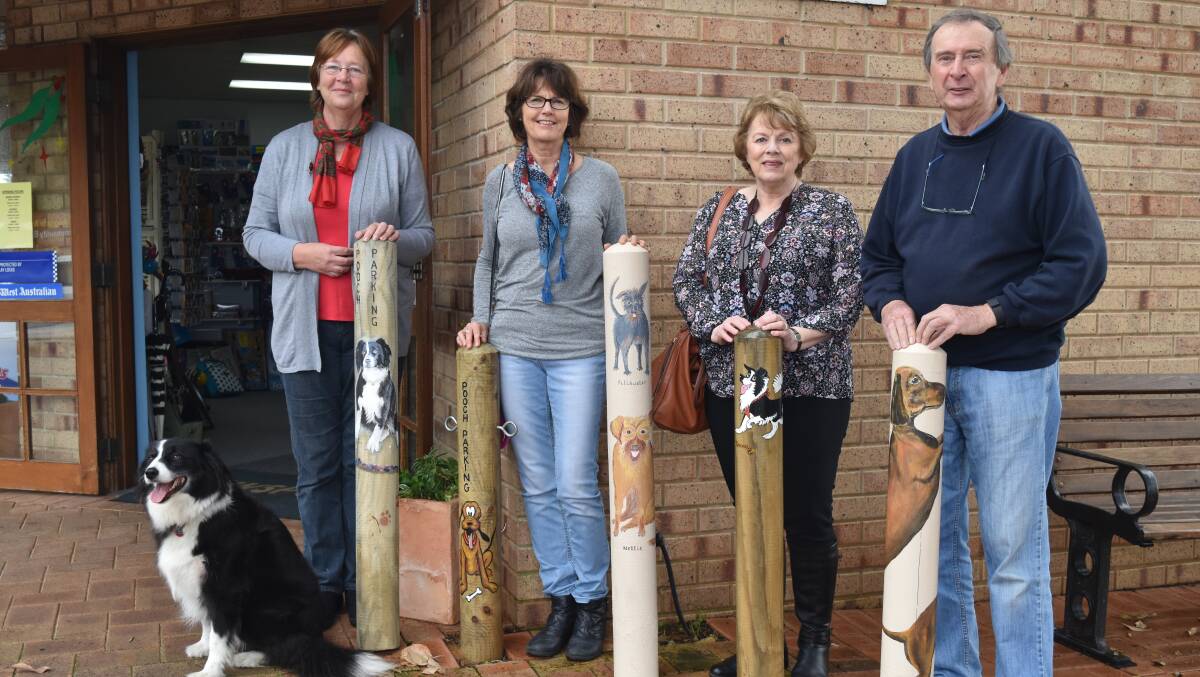 Pooch patrol: Wendy Strucelj, Lynne Orriss, Carol Lyons and Owen Fletcher with their painted poles with Holly the Hardware Hound looking on. Absent from the painting team are Jan Garthe and Morren Hansen.