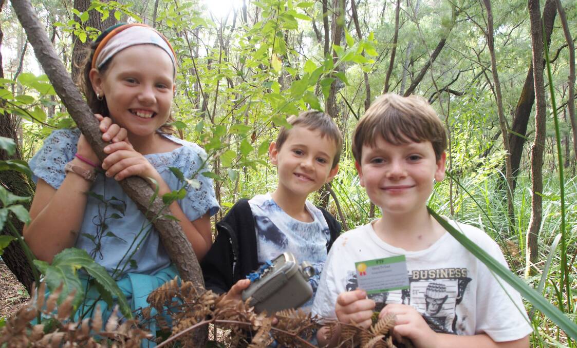 Sophie, Hayden and Thomas Baker discover their first geocache for the day. 