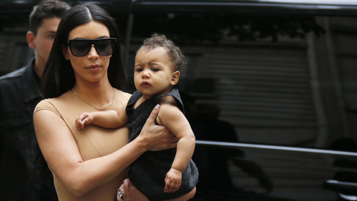TV personality Kim Kardashian holds her daughter North in her arms as she shops in Paris May 20. Busselton-Dunsborough Mail journalist Jade Jurewicz writes about competitive mums in this week's column. Photo: Reuters/Gonzalo Fuentes.