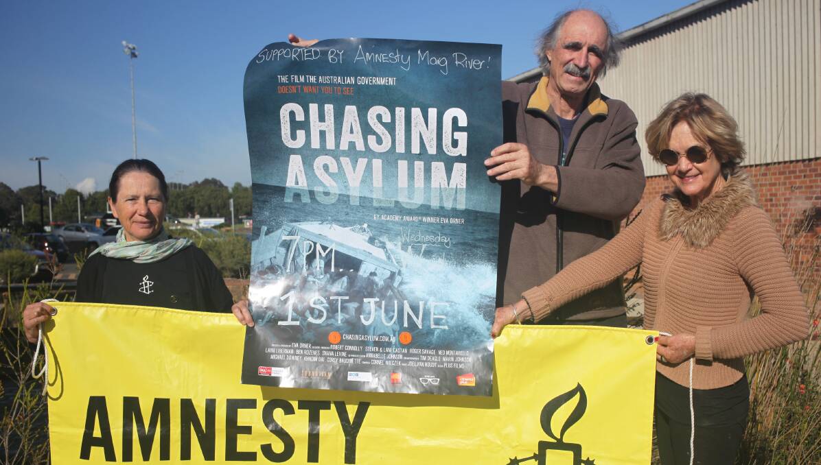 Amnesty Margaret River's Chris Berrill, Rod Whittle and Pauline McLeod with the poster for the film, Chasing Asylum. Photo - Anita Haywood