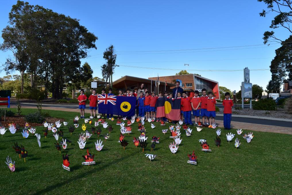 Healing hands: Year 3 St Thomas More students, teacher Demi Wright and principal Martin Major with their 'Sea of Hands' created to mark Reconcilation Week. Photo: Nicky Lefebvre