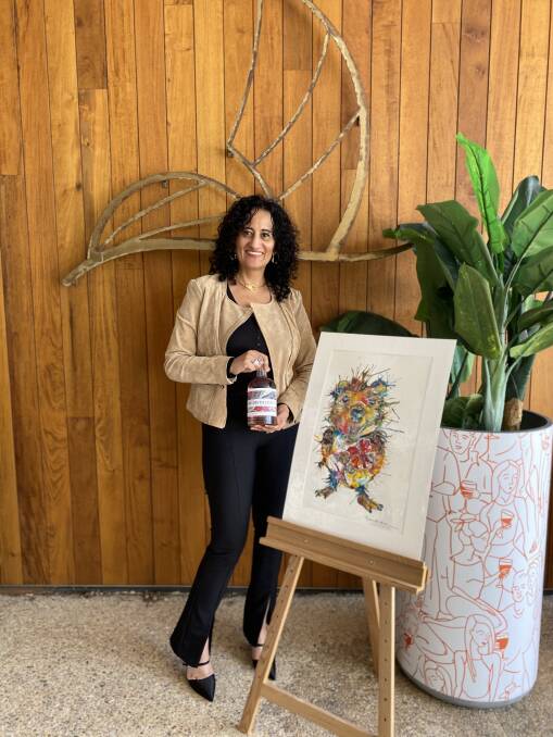 Artist Rina Bhabra with Quokka painting, featuring on the Rhubarb & Hibiscus gin label.