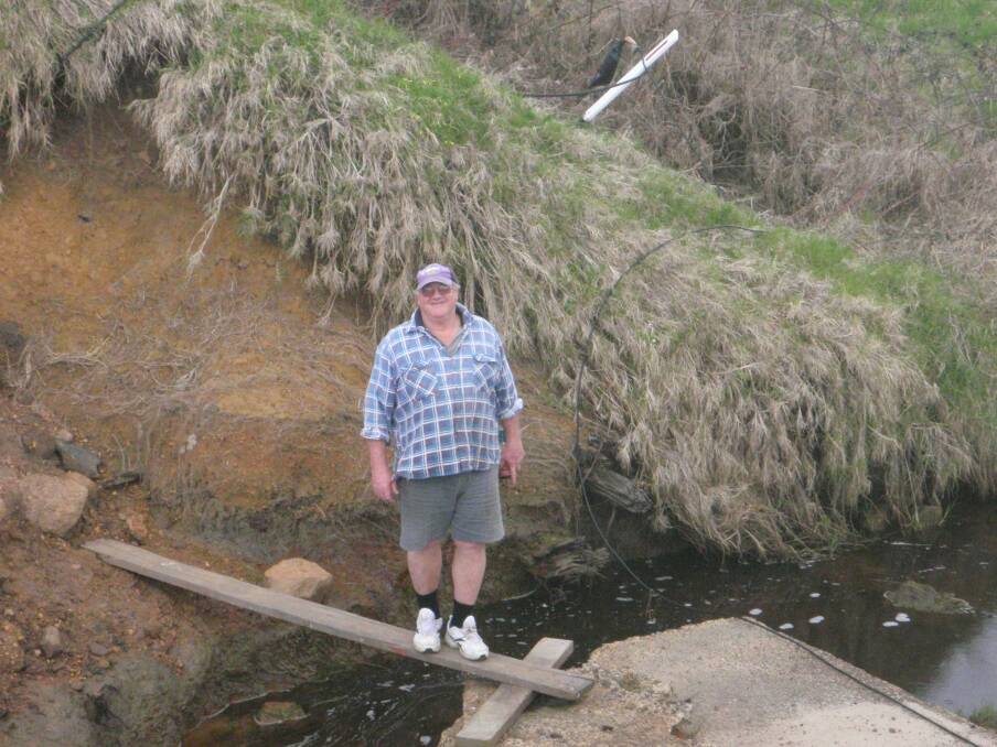 Makeshift bridge: Terry Dryden, a Warner Glen Resident, shows how people manage to get across the road's collapse.