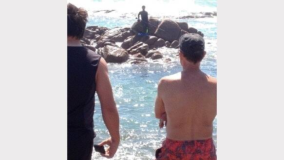 HAIRY EXPERIENCE: This man was trapped on rocks for about two hours while sharks cruised in the water.