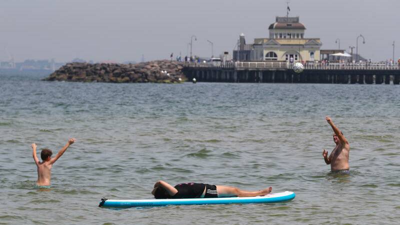 Beachgoers are seen during a hot day at St Kilda beach in Melbourne.