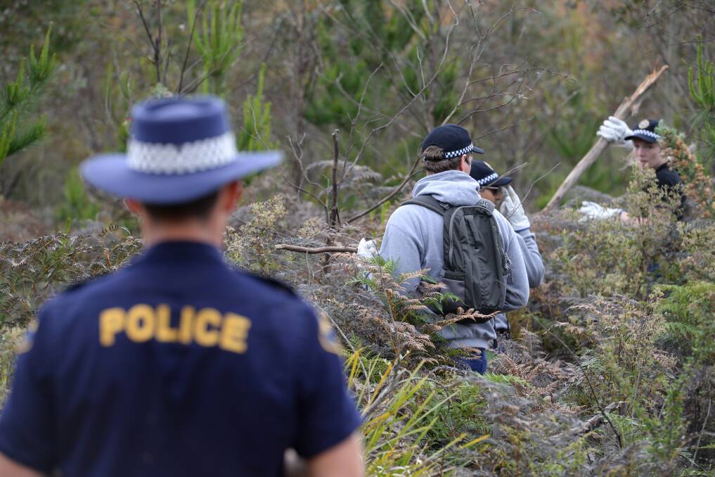 Police search the Dulverton bushland where Mr Ingham's body was found. 