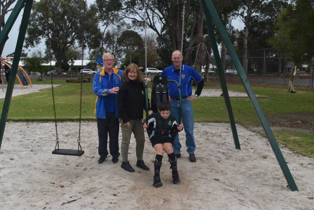 Jo Cook and a student from Margaret River Primary School test out the newly installed swing, with Margaret River Lions Club's Brian Prendergast and Nigel Vangucci. 