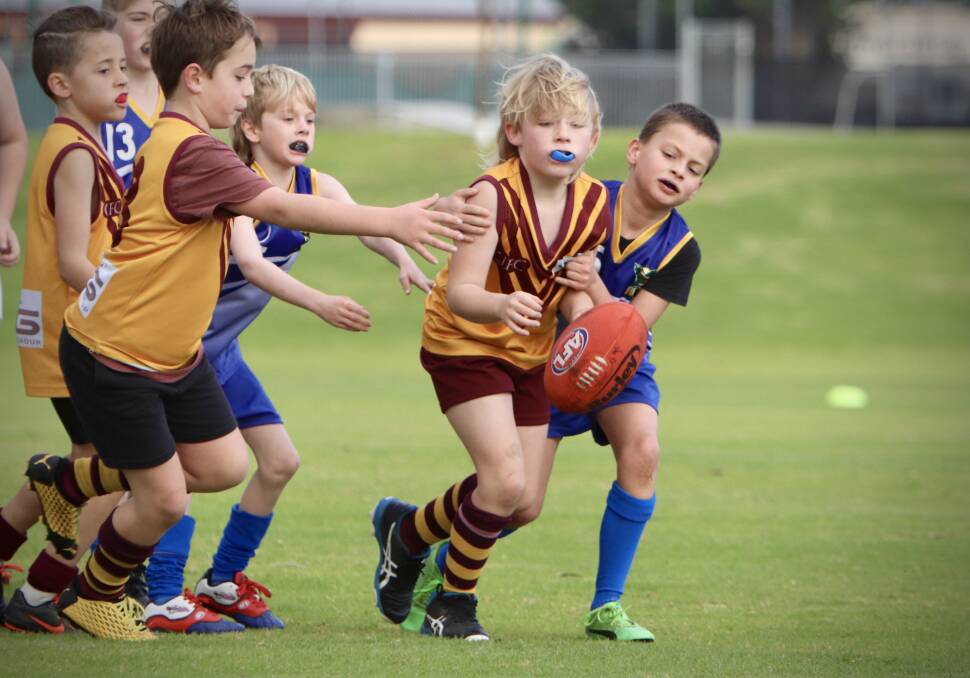 Youth & determination: It was a tough contest between Bulls Gold 9s and Hawks Blue at Cowaramup. Photo: Chloe Motzouris.