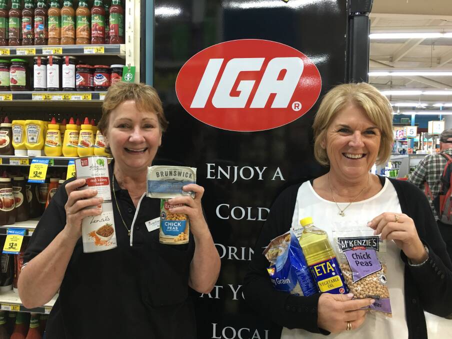 Challenging task: Sue Noakes (left) and Debbie O'Connor at Riverfresh IGA with items available in the ration kits. Photo: Anita Haywood.
