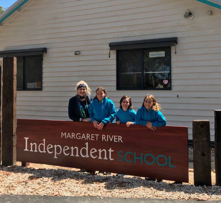 Margaret River Independent School Principal Wendy Roediger (left) checks out the new school sign with students. 