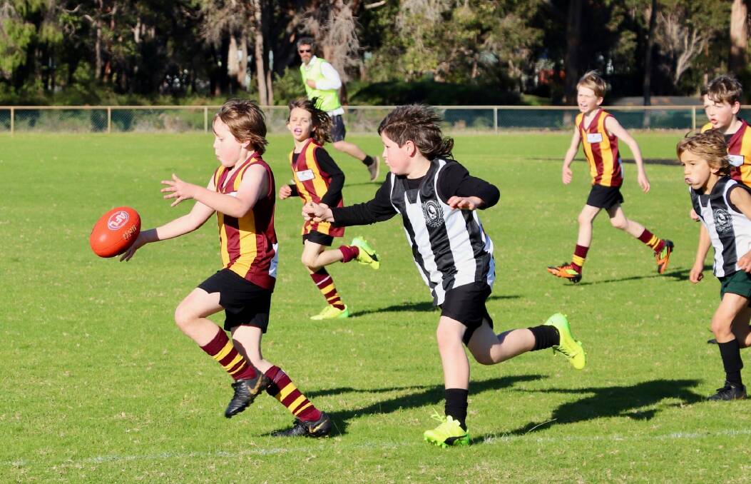 Quinn Nash bolts away from his opponent for Bulls Red 9s at Augusta on Saturday. Photo: Chloe Motzouris.