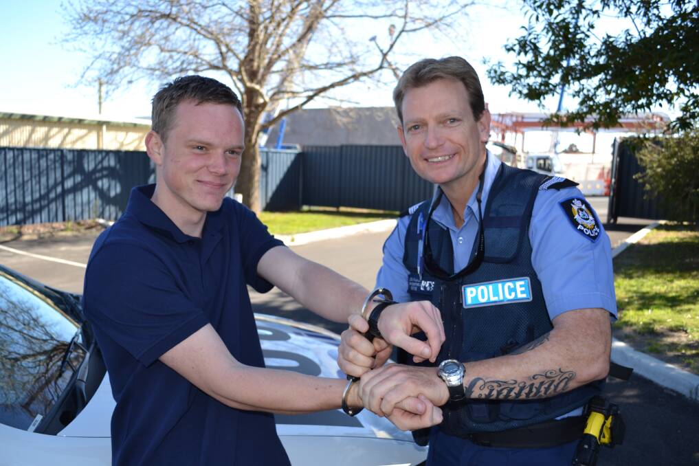 HOOKED ON POLICING: Future police officer and work experience student Zachary ‘Agent Max’ McDonald and Senior Constable Leon Parish mug for the camera. Picture: Trent Neal